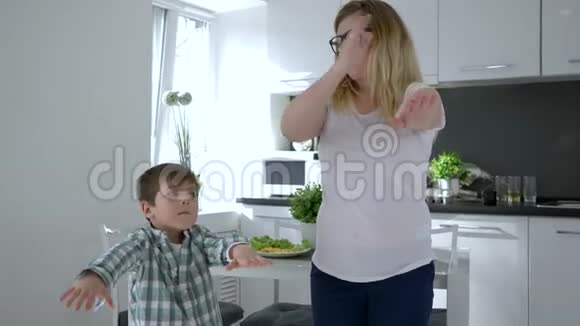 现代舞蹈戴眼镜的妈妈在厨房教儿子跳舞视频的预览图