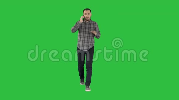 严肃的男人在绿色屏幕上行走和说话Chroma键视频的预览图