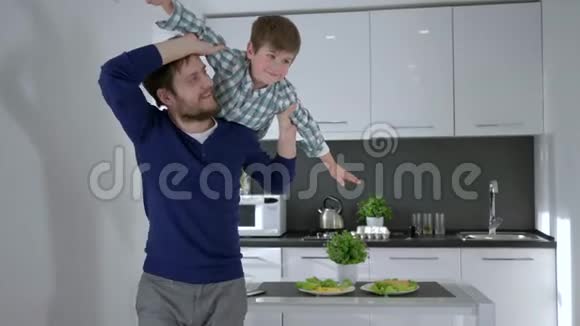 童年快乐年轻的父亲把儿子抚养长大双手在厨房里搭飞机视频的预览图