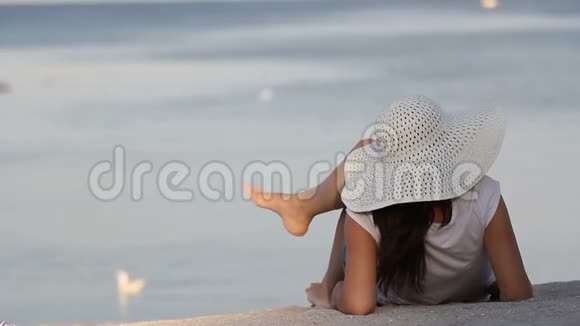 躺在沙滩上望着大海的年轻女士视频的预览图