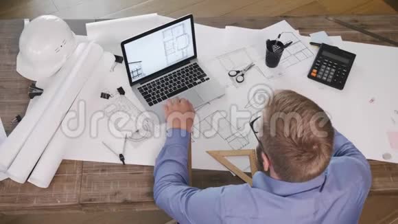 一名男性工程师在笔记本电脑上工作的俯视图视频的预览图