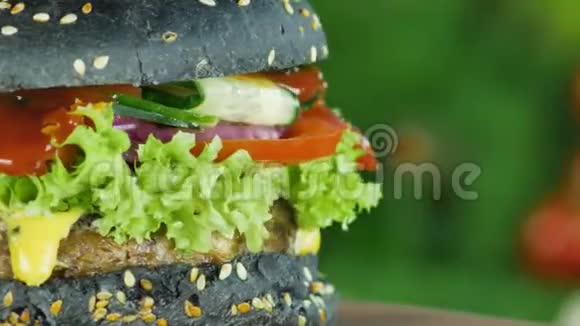 汉堡或汉堡包牛肉和黄瓜在莴苣叶和蔬菜的背景下模糊旋转视频的预览图