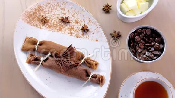 巧克力俄式薄饼布里尼和凝乳馅在盘子里提供了一杯茶和巧克力上景视频的预览图