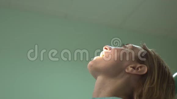 年轻成功的牙科医生用牙科设备为临床上的美丽女性患者治疗牙齿视频的预览图