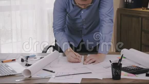建筑师拿着笔在桌子上办公室里有一张蓝图视频的预览图