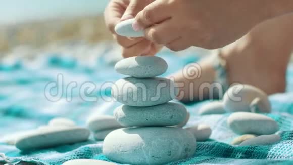 幼儿手工在海边搭建鹅卵石塔平衡圆石堆视频的预览图