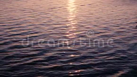 阳光在水中闪烁粉红色的夕阳在波浪中反射视频的预览图