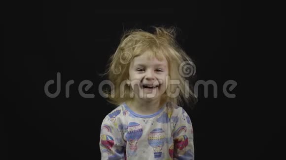 睡衣里的小女婴在到处瞎弄鬼脸黑色背景视频的预览图