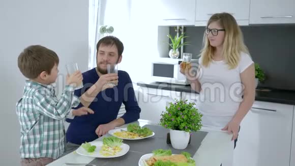 家庭早午餐可爱的孩子和父母一起在家吃饭时用果汁做丁丁杯视频的预览图