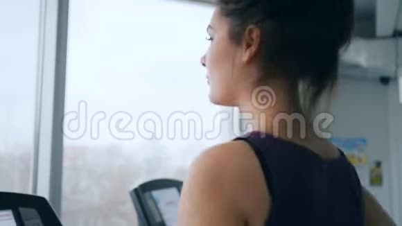 健身中心可爱的女士在健身室的特写镜头中跑步机上跑步视频的预览图