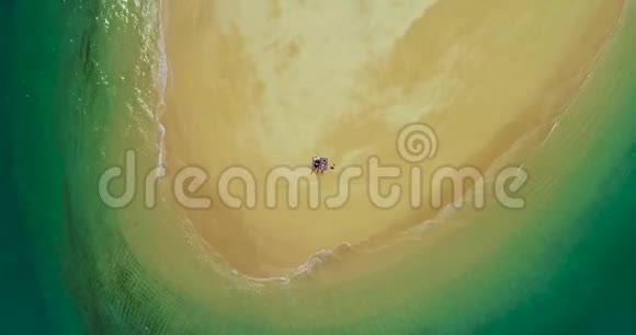 空中一对夫妇在海滩上的荒岛上进行日光浴视频的预览图