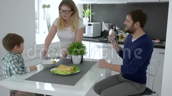 一家人的早晨妈妈把鸡蛋放在桌子上喂丈夫和儿子视频的预览图