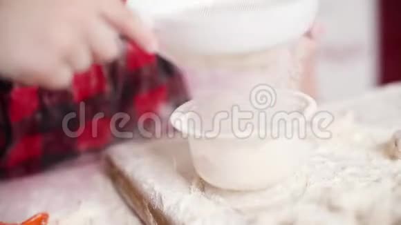 小可爱的女孩在厨房用过滤器过滤面粉视频的预览图