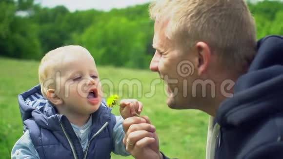 年轻快乐的父亲和小儿子在公园玩耍微笑视频的预览图