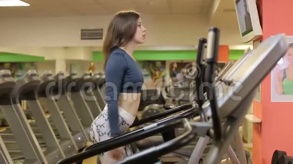 那个女孩在健身房的跑步机上跑步健身理念视频的预览图