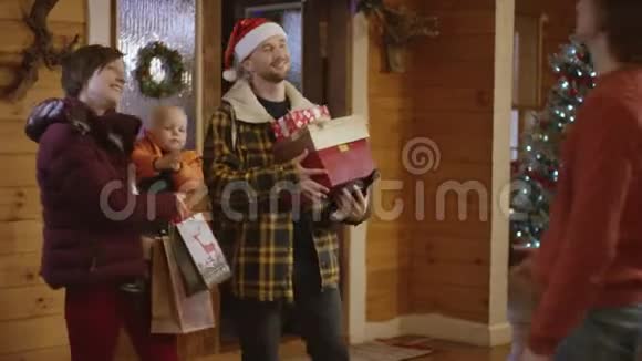 一对有小孩的家庭夫妇给朋友送圣诞礼物和酒瓶视频的预览图