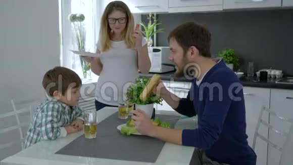 快乐的食物年轻的家庭同时咬着髻在家大笑视频的预览图