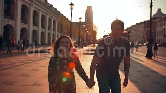 玩得开心的年轻夫妇正在大街上跳着笑视频的预览图
