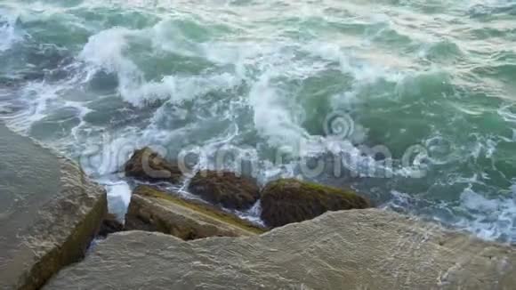 海浪以缓慢的速度撞击岩石和石块视频的预览图