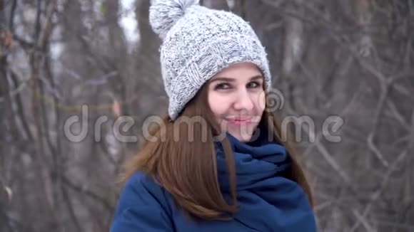 特写一幅时尚的年轻美丽的女人在雪地背景下的冬天公园里微笑的肖像年轻漂亮的模特视频的预览图