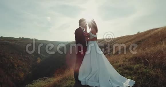 美丽的新郎和新娘站在山顶上视频的预览图
