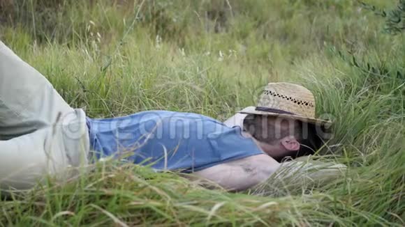 男性模特放松躺在田野里视频的预览图