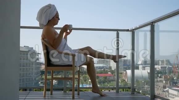 享受水疗后的快乐女人到阳台喝咖啡视频的预览图