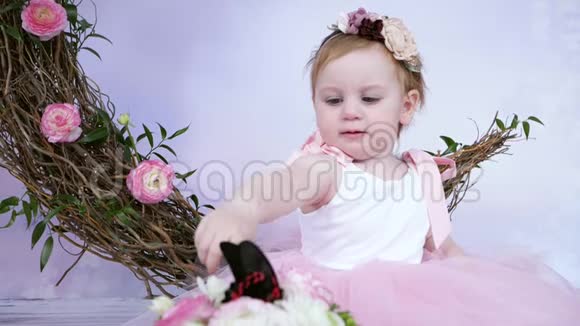 可爱的小女孩穿着粉红色连衣裙在现场大蝴蝶在白色背景和室内装饰视频的预览图