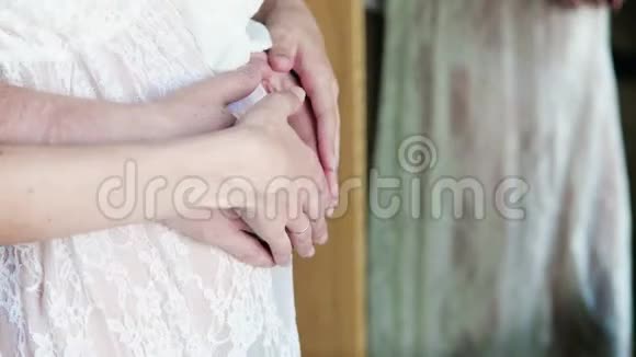 丈夫在特写镜前拥抱怀孕的妻子男性手在镜子反射中抚摸怀孕的腹部视频的预览图