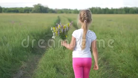 可爱的小女孩跑在草地上穿着花的颜色无忧无虑的童年小女孩在夏天玩耍视频的预览图