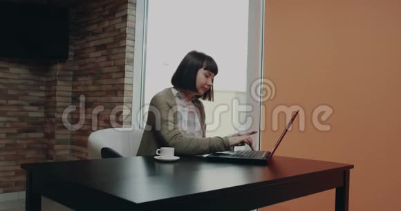 在她的办公桌上漂亮的女性使用她的信用卡并从笔记本电脑上订购一些东西4k视频的预览图