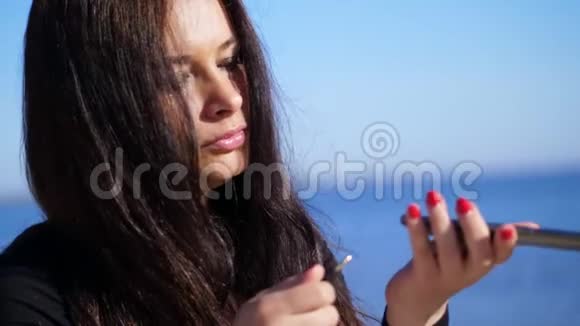 夏天早上一个漂亮的四十岁的女人留着长长的黑发手里拿着一部手机一个设备她是个女人视频的预览图