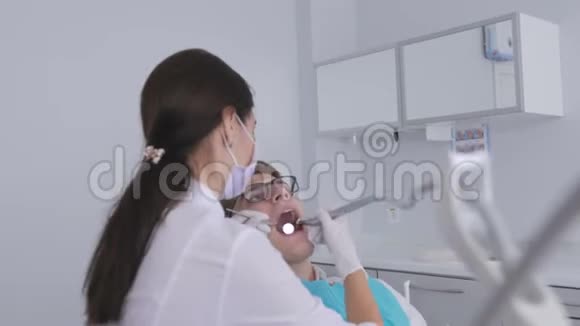 在牙科治疗期间一位病人坐在牙科椅上用智能手机拍下自己的照片视频的预览图