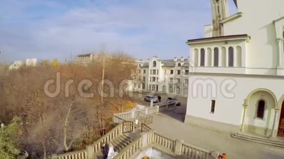 空中观景在古教堂附近的秋天公园里举行婚礼视频的预览图