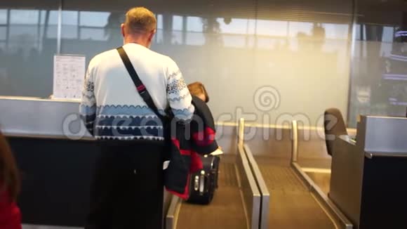 机场的航空公司乘客一名男子在机场办理登机手续托运行李的后视镜视频的预览图
