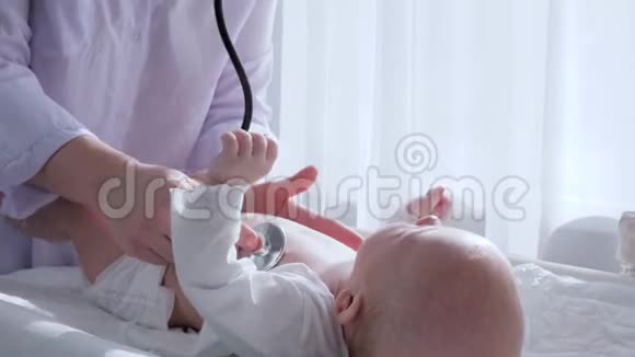 医用检查护士用听诊器在白色窗帘背景下听医院新生儿心脏视频的预览图