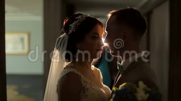 新婚夫妇摸鼻子的肖像背景中点亮聚光灯视频的预览图