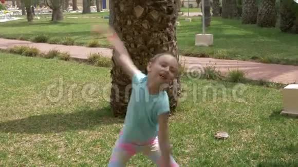 夏日公园的背景棕榈树上微笑的少女翩翩起舞视频的预览图