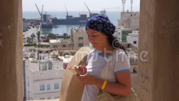 女人在后台使用带有码头的智能手机视频的预览图