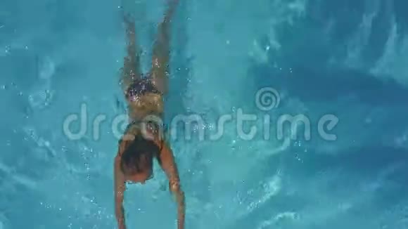 女人在蓝色的游泳池里游泳做波浪视频的预览图