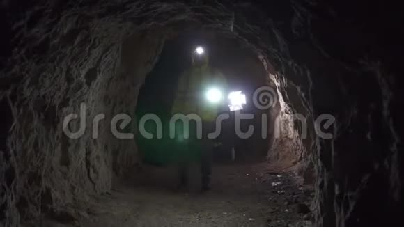 一名志愿者手里拿着手电筒额头上拿着手电筒在山洞里寻找一个失踪的人视频的预览图