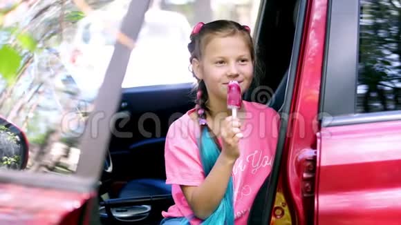 肖像画八岁的漂亮女孩金发有雀斑还有多种颜色的辫子在一个粉红色的冰淇淋上吃视频的预览图