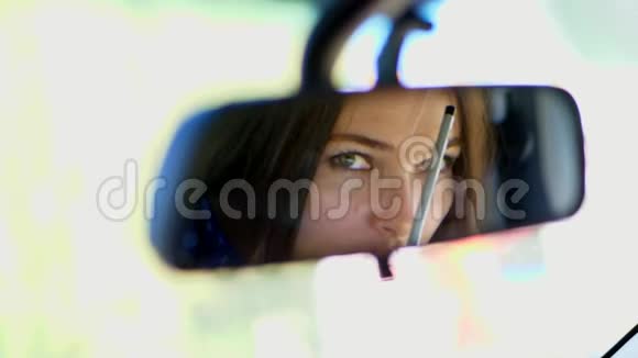 一位美丽的黑发女人艺术家坐在车里看着后视镜2她挺直腰板视频的预览图