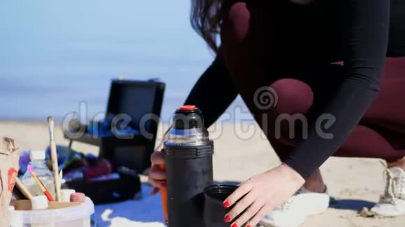 夏天海边日出女艺术家在业余时间画画有小吃野餐午餐户外早餐关闭视频的预览图