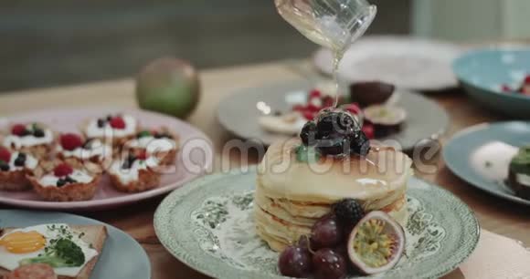 特写美味的煎饼上面有蓝莓和蜂蜜在缓慢的运动视频的预览图
