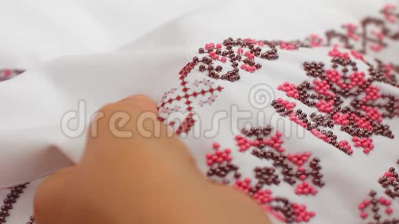 针与线的特写珠的刺绣图案手工缝制婚纱视频的预览图
