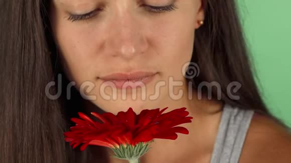 一位美丽的年轻女子在闻一朵花时笑得很开心视频的预览图