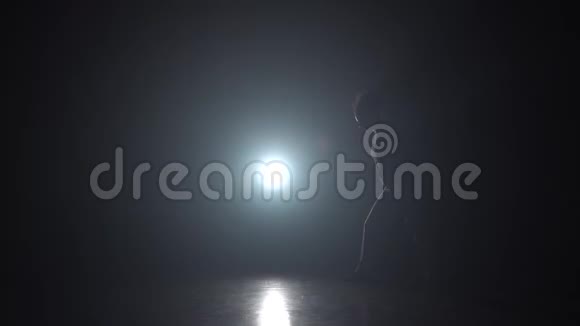 卡波伊拉黑暗中的女人在灯光照射下的剪影慢动作视频的预览图