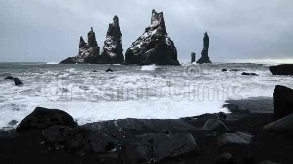 玄武岩岩石巨魔脚趾在黑色海滩在雷尼斯德拉加尔风暴维克冰岛视频的预览图