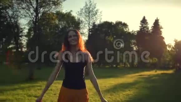 穿着红色长裙的年轻女子在公园里户外跳跃和跳舞视频的预览图